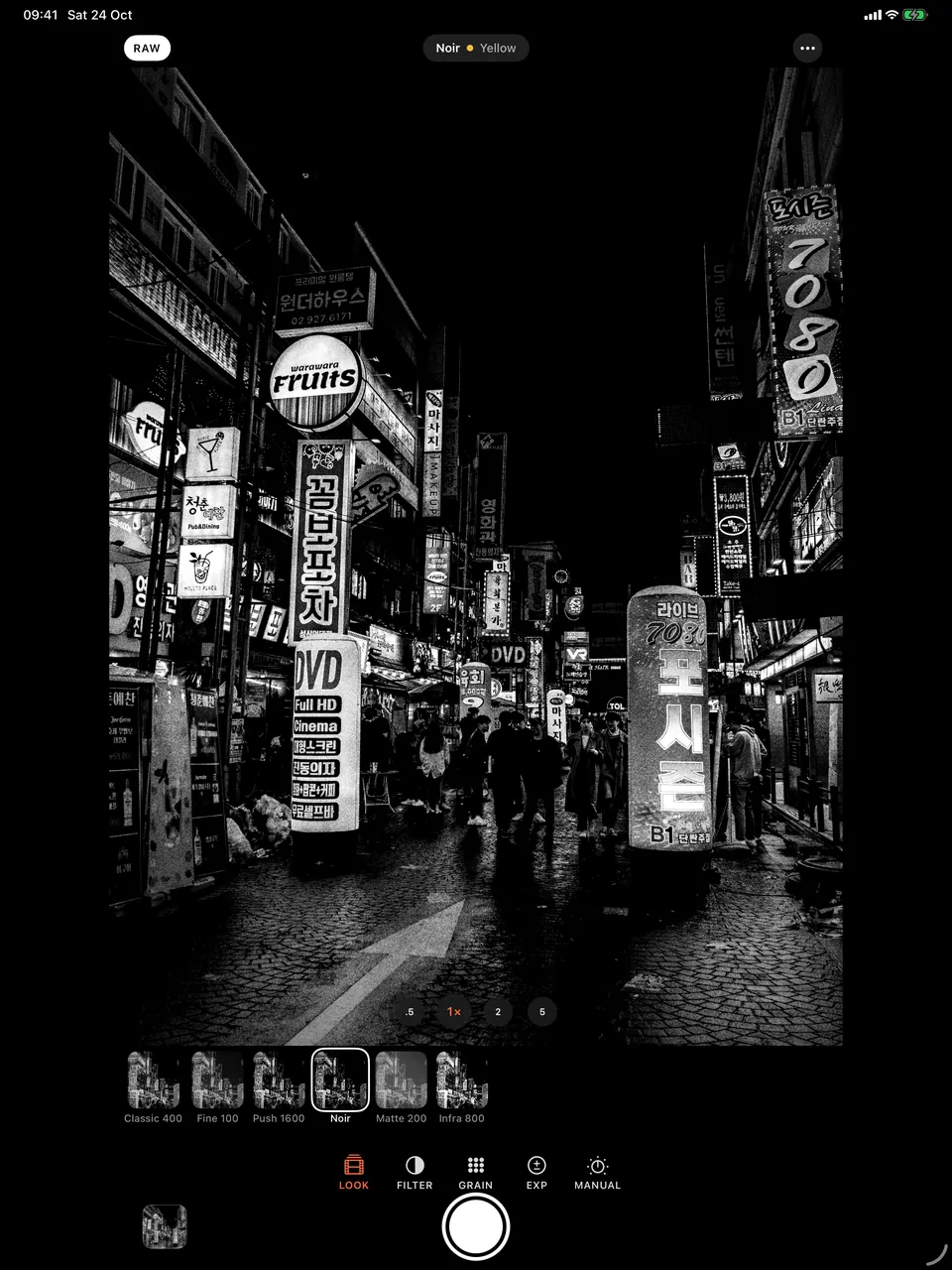 B&W Camera on iPad with the Looks tray open and Noir selected over a neon street at night